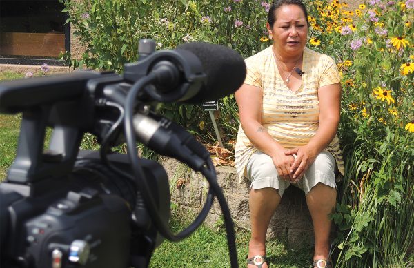 A women sitting in front of a camera being filmed.