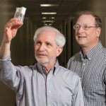 Two men looking through test tubes