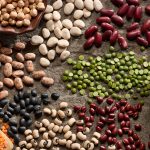 A variety of peans spread out on a table.