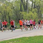A group of people on a run down the street.