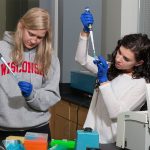 Two students working in a lab with pipets
