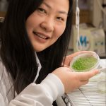 A woman smiling with a pea tree dish