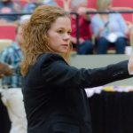 A woman directing animals in an arena