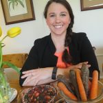 women sitting at a table smiling with tulips and carrots