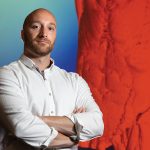 Adam Kuchnia stands in front of a projected 3D image of human torso muscles created from dozens of cross-sectional CT scans. Photo by Michael P. King