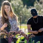 Two students standing in an outdoor garden looking at the plants