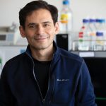 Daniel Amador smiling for the camera in a lab