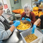 From left, undergraduate students Michael Gilpin, Autumn Chevalier, and Patricia Castillo Venegas BSx'20 remove squash seeds for saving at FEED Kitchens in Madison, Wis.