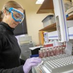A woman scientist works in a lab.
