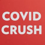 Red background with partial images of the novel coronavirus in the background and "COVID CRUSH" written in all-caps in white.