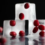 Cranberries frozen into three stacked ice cubes.