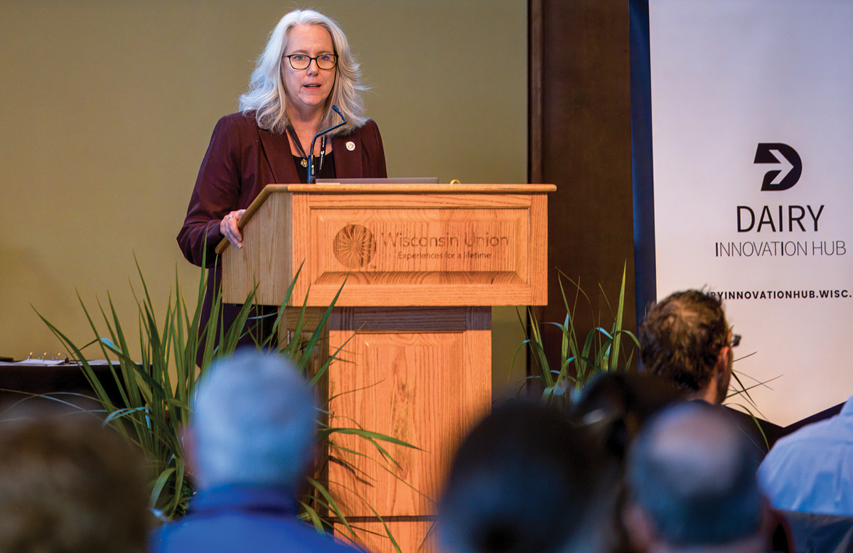 Dean Glenda Gillaspy stands at a podium in front of a crowd speaking.