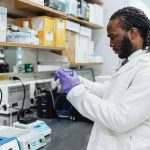Brodie works at a lab table, examining vials.
