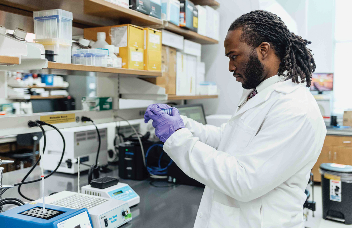 Brodie works at a lab table, examining vials.