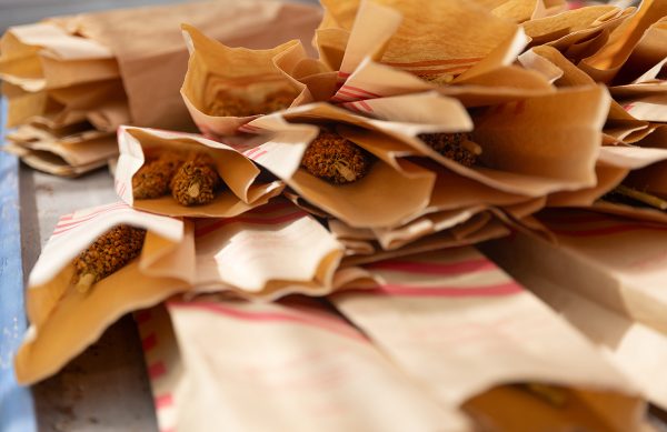 A pile of paper bags full of sorghum seeds.