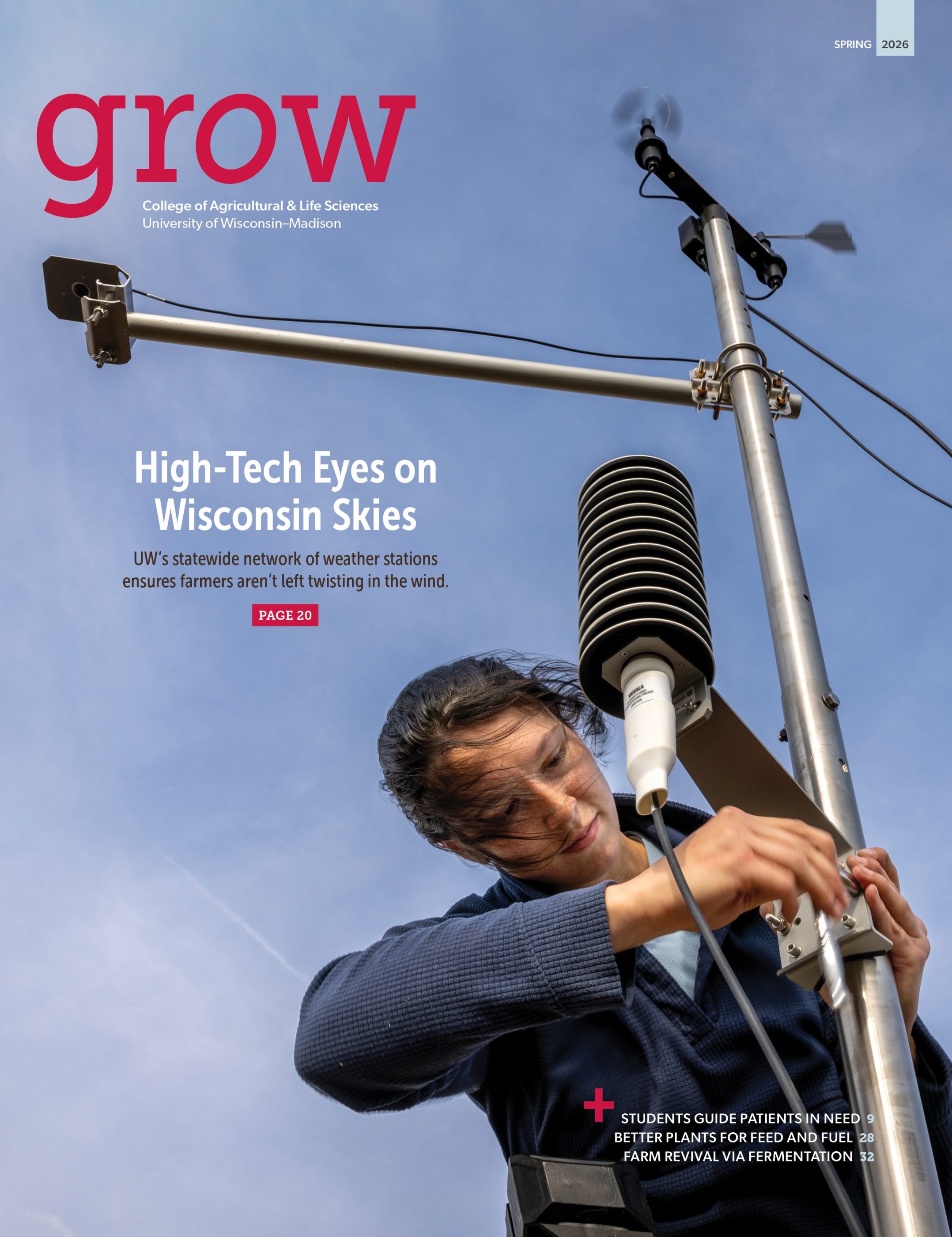 A magazine cover with title of the publication in the upper-left corner, the issue in the upper-right corner, and additional text about the cover story near the center. photo takes up the entire cover. Viewed from below, a woman attaches a piece of equipment to a vertical metal pole, which has a horizontal metal pole and additional equipment attached above her. It's a weather and soil monitoring station. A blue sky in the background takes up the entire frame. The woman's dark hair blows in the breeze.